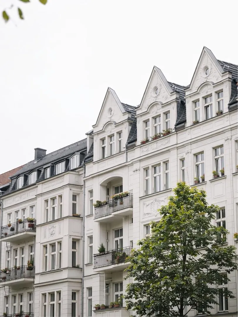 Eine Häuserreihe im Jugendstil mit weißen Fassaden, Dachgauben und Balkonen.