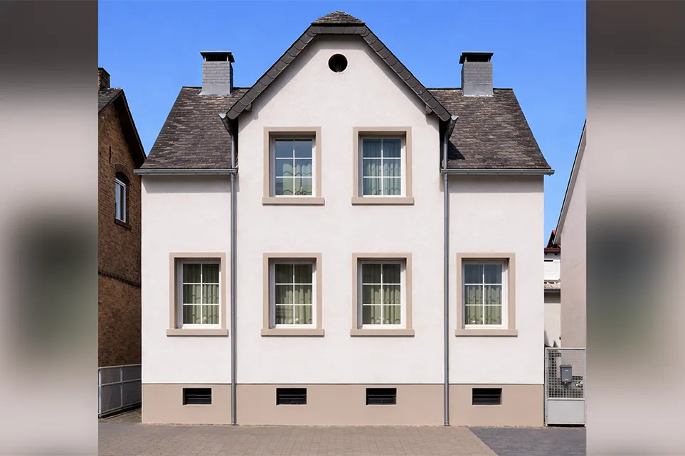 Ein kernsaniertes Haus mit heller Fassade und hellbraunen Akzenten.