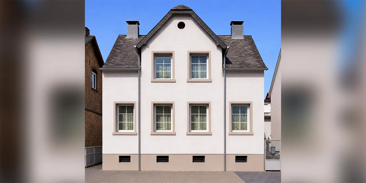 Ein kernsaniertes Haus mit heller Fassade und hellbraunen Akzenten.